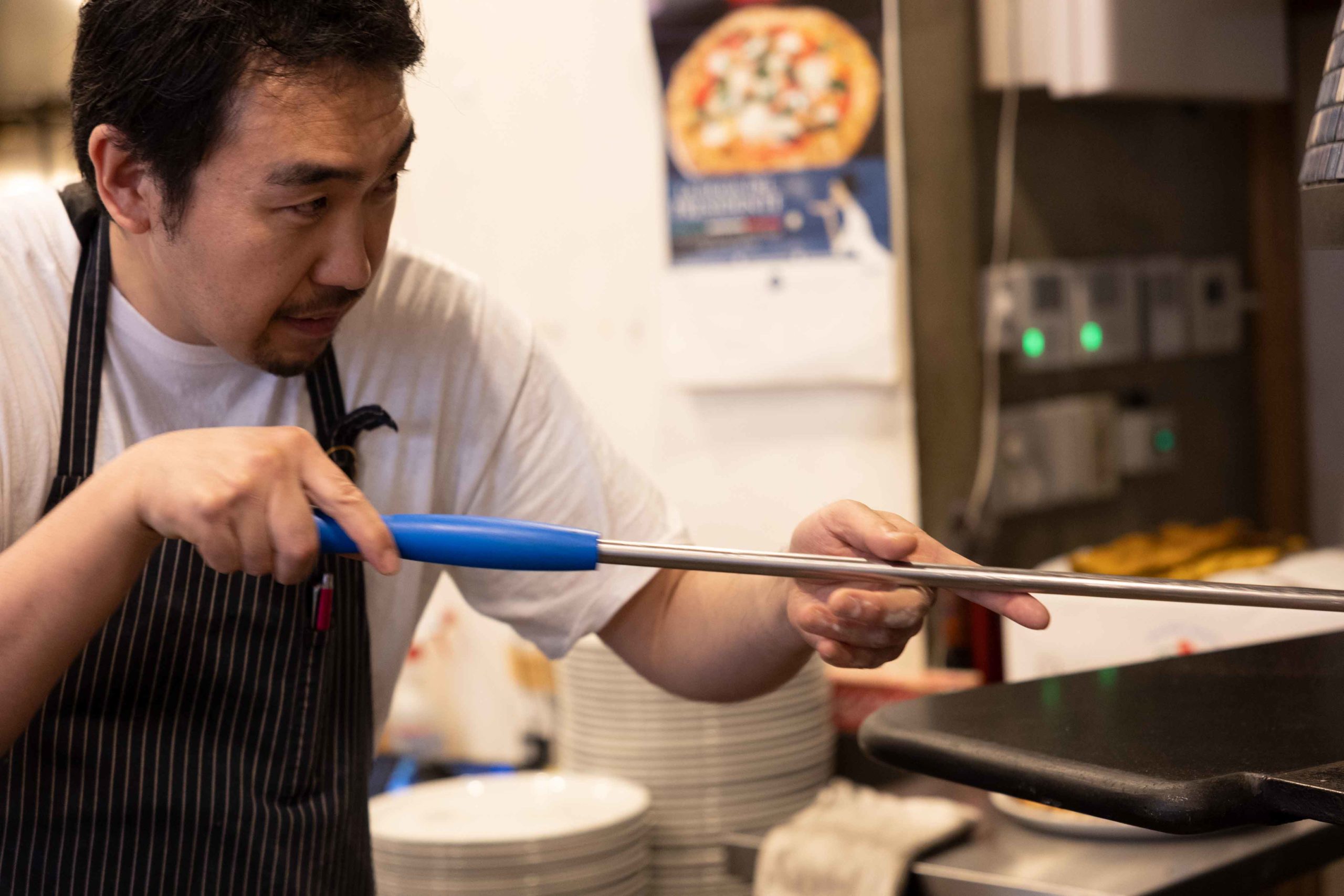 厨房でピザを調理するシェフ