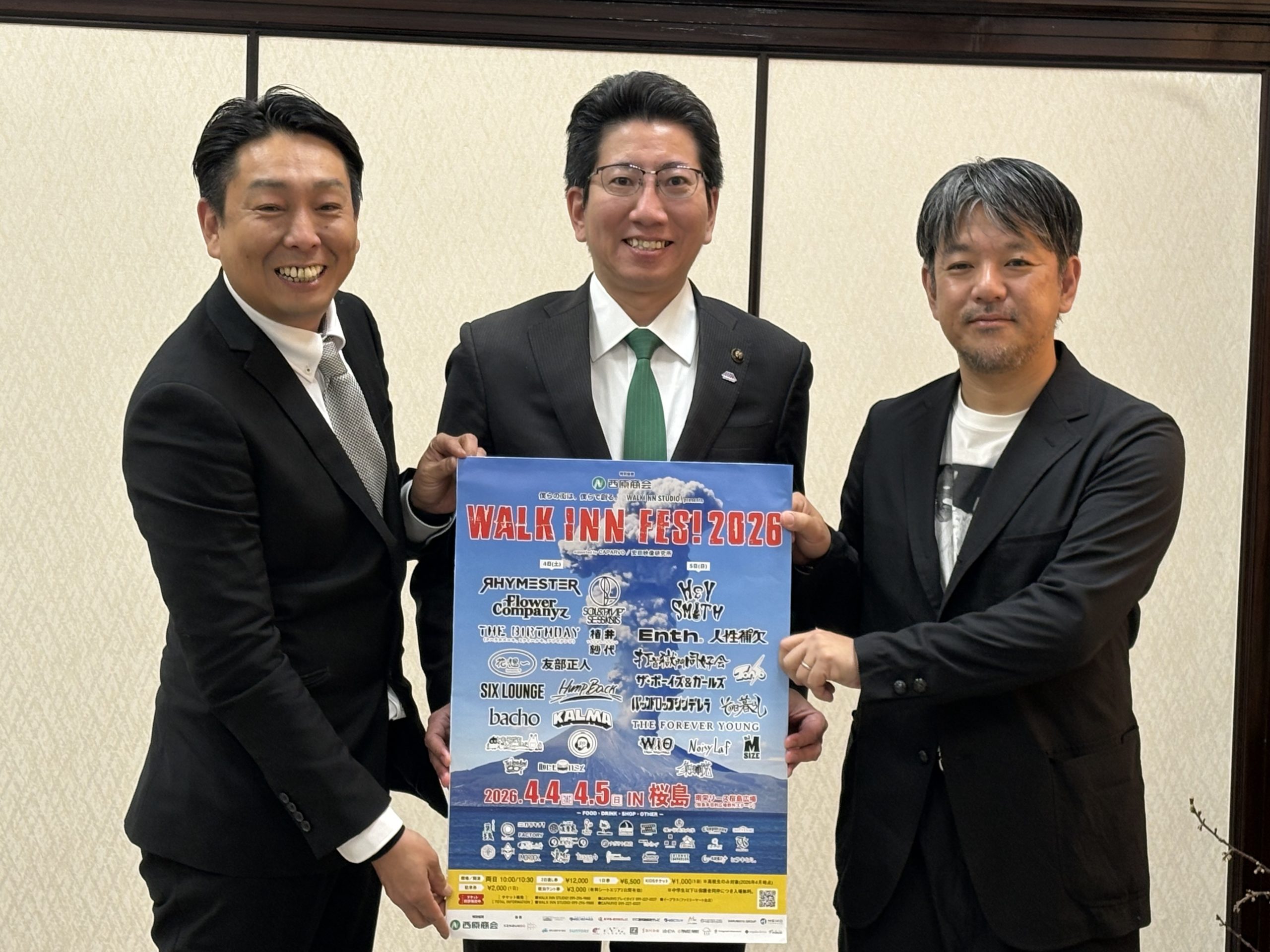 イベントポスターを持つ3人の男性