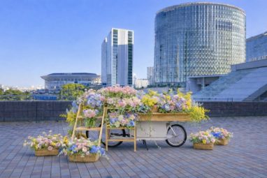 花で飾られた自転車と都市の背景