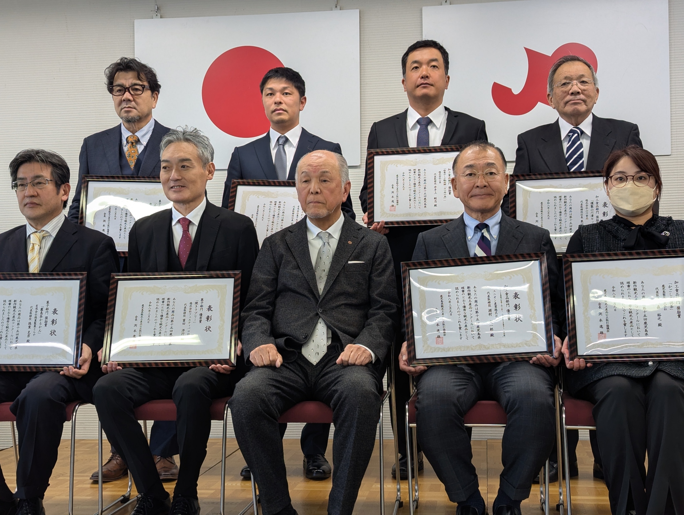 表彰状を持つ人々の記念写真